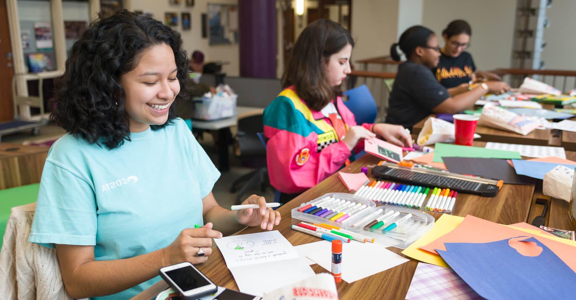 four students working on cards at a table